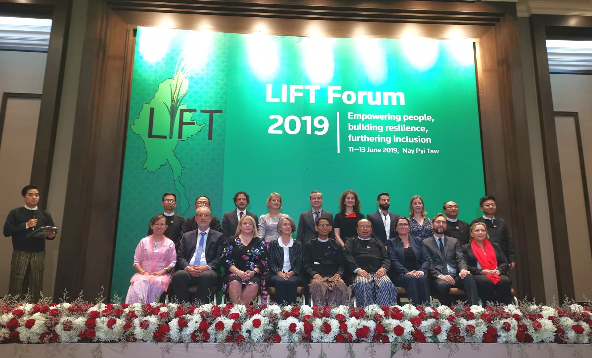 Delegates on the main stage beneath the forum backdrop