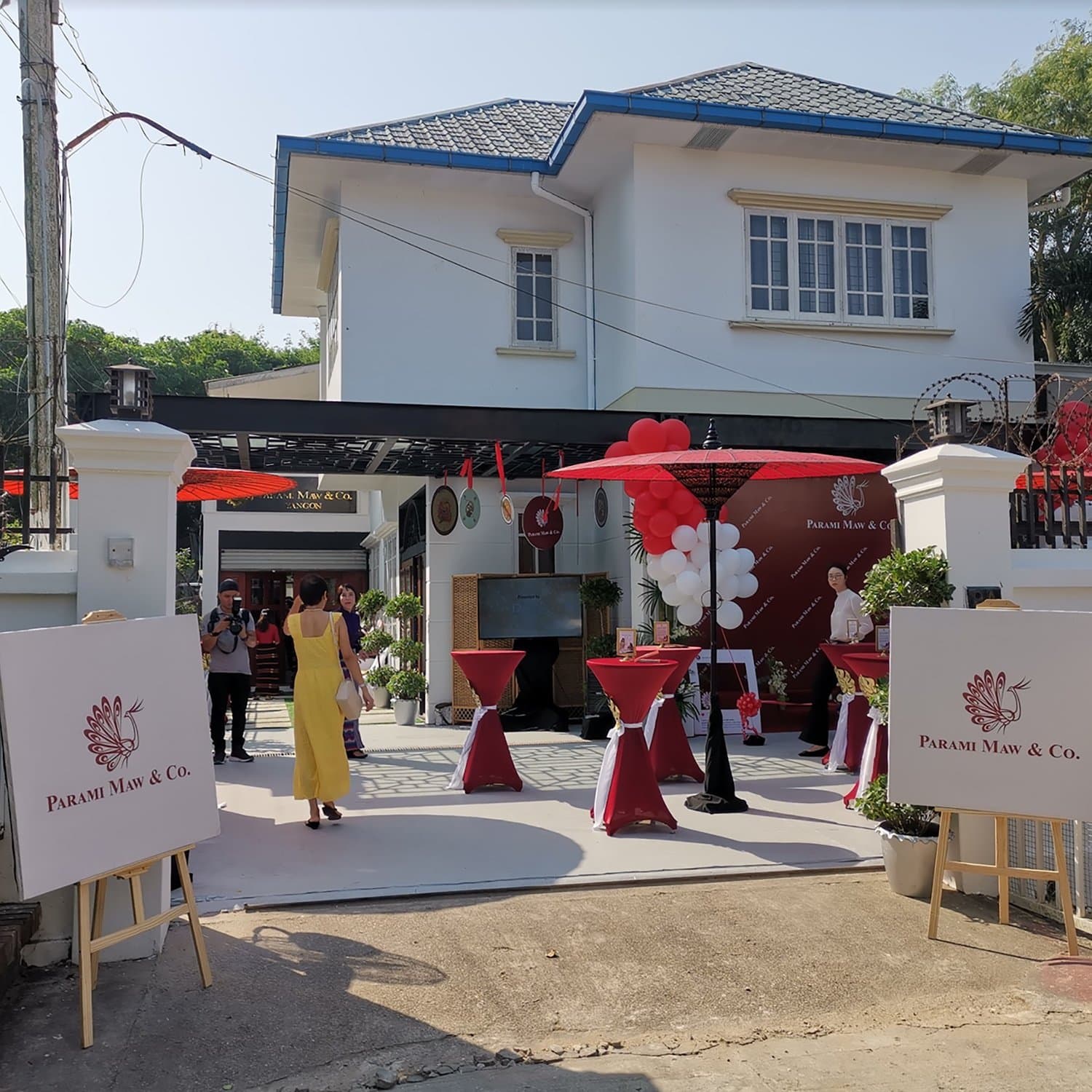 Boutique entrance dressed with parasols, balloons and easel signage