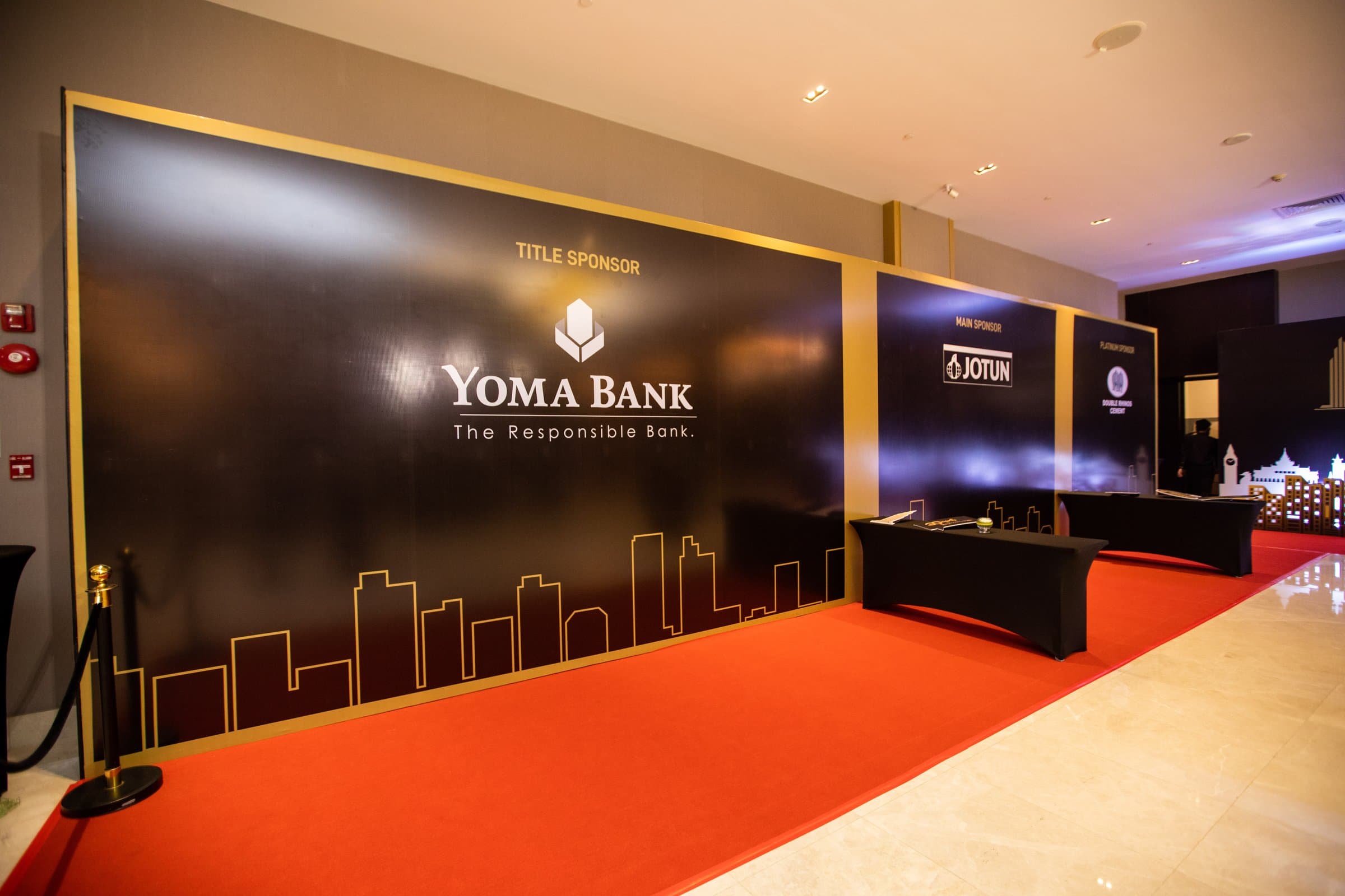 The red-carpet arrival wall, gold skyline on black