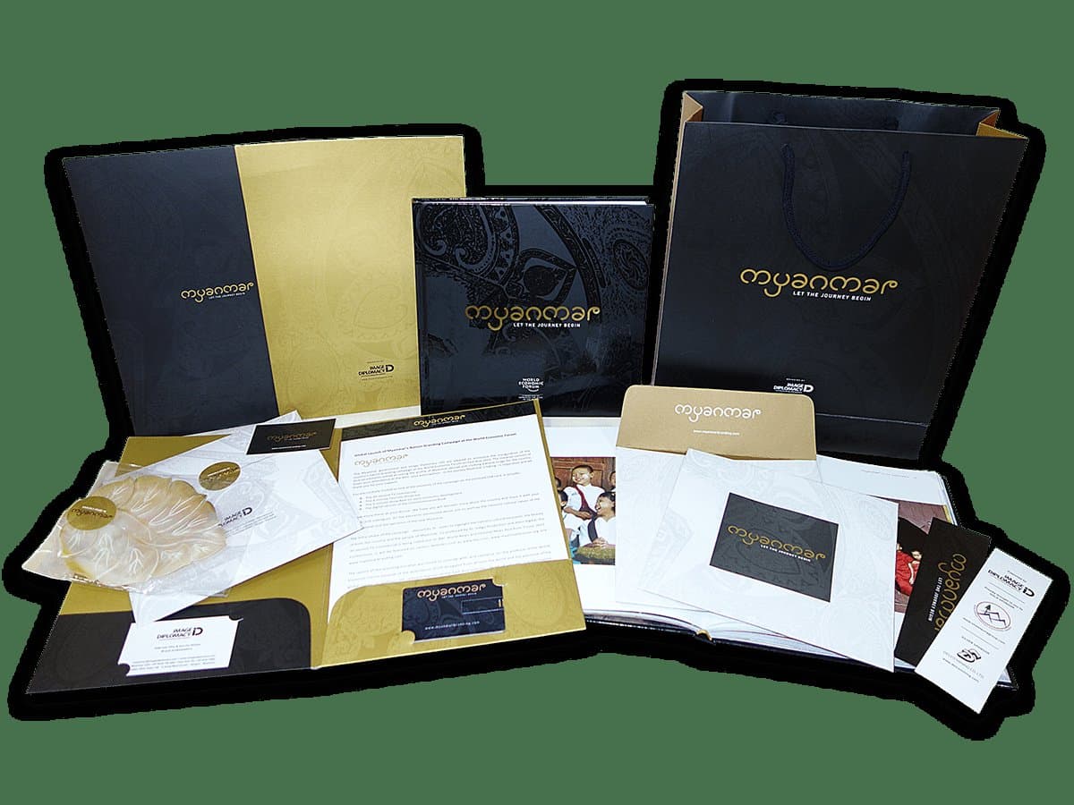 Delegate kit — folders, bags, envelopes and cards in the black-and-gold identity